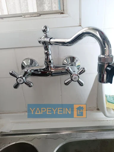 Επαγγελματίας υδραυλικός της ΥΔΡΕΥΕΙΝ τοποθετεί μπαταρία κουζίνας